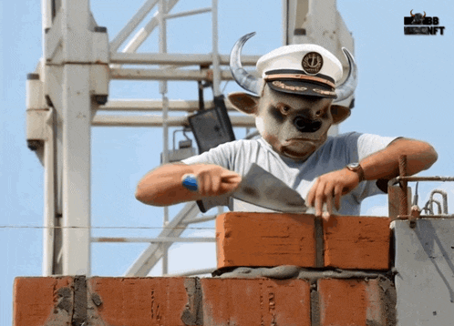 a man wearing a bull mask and a captain 's hat cuts bricks