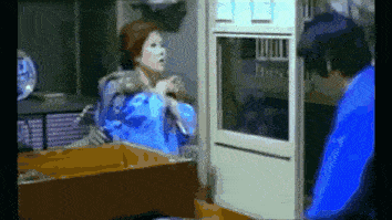 a man in a blue shirt stands next to a woman in a blue robe