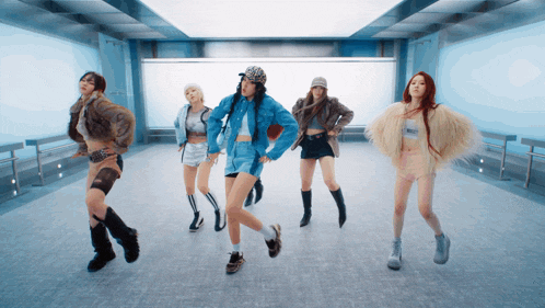 a group of women are dancing in a room with one wearing a crop top that says ' i love you ' on it