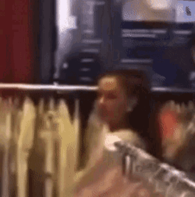 a blurry picture of a woman sitting in a chair in a room .