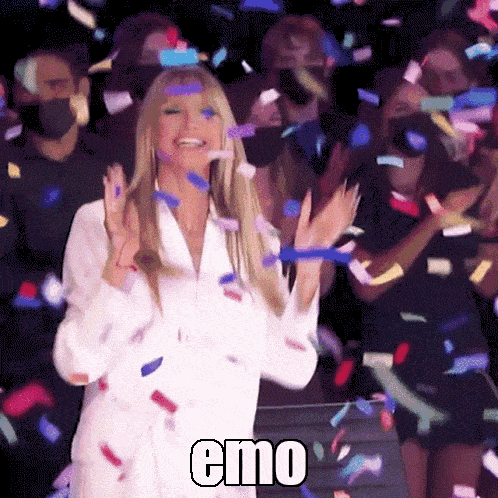 a woman in a white shirt is surrounded by confetti and the word emo is on the bottom right