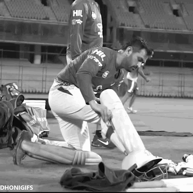 a black and white photo of a cricket player with hil on his jersey