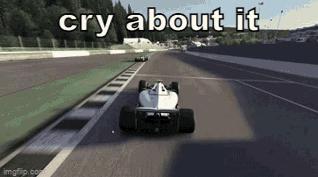 a white race car is driving down a race track with the words cry about it above it