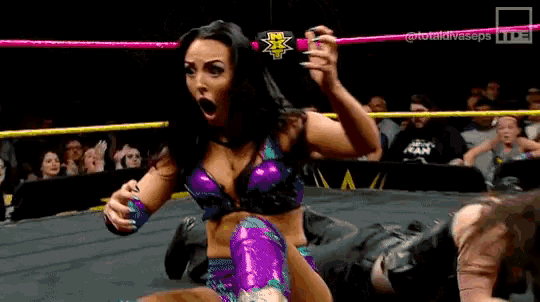 a woman in a wrestling ring is holding a can of soda in her hand