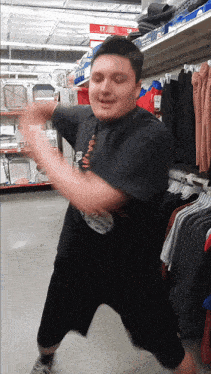 a man dancing in a store with a sign that says 17 in the background
