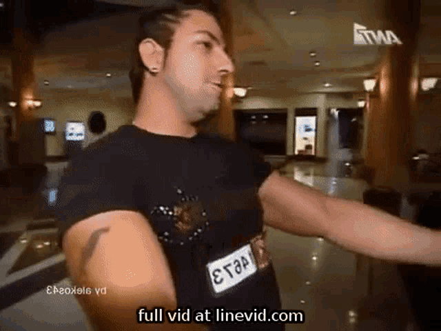 a man wearing a black shirt with a tag that says e.t.a. on it
