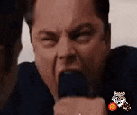 a man is making a funny face while holding a microphone in his hand .