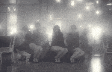 a group of people are dancing in a dark room with a light that says ' y ' on it