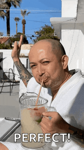 a man drinking a drink with a straw and the word perfect behind him