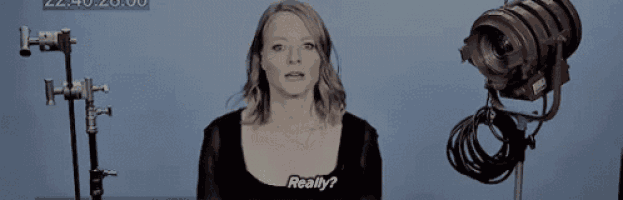 a woman is standing in front of a camera and asking really