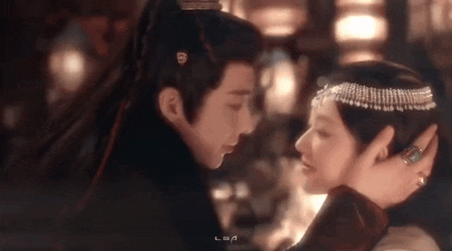 a man and a woman are looking into each other 's eyes in a dark room .