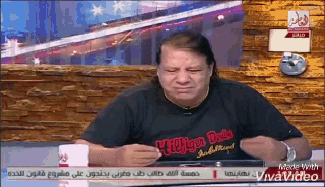 a man wearing a black t-shirt that says hilfiger denim