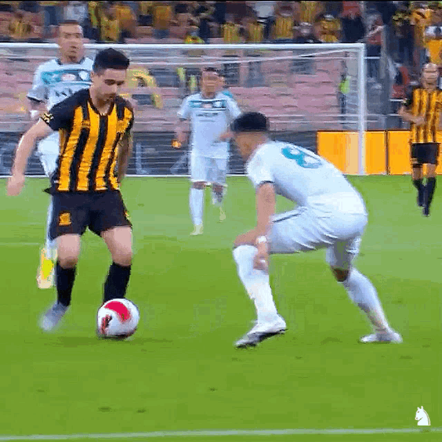 a soccer player wearing a yellow and black striped jersey with the number 9 on the back