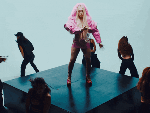 a woman in a pink hooded jacket is standing on a stage