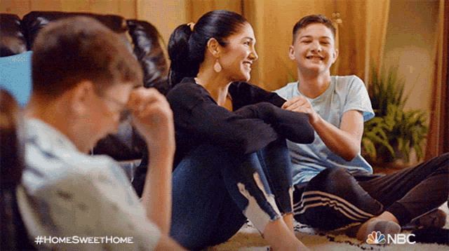 a family sits on the floor in a living room with nbc written on the bottom