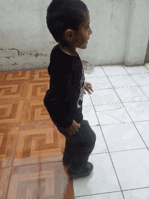 a little boy wearing a black shirt with a skull on it