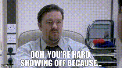 a man in a suit and tie is sitting in a chair and says ooh you 're hard showing off because .