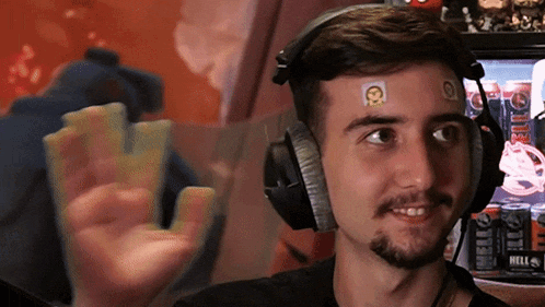 a man wearing headphones has stickers on his forehead including one that says hell