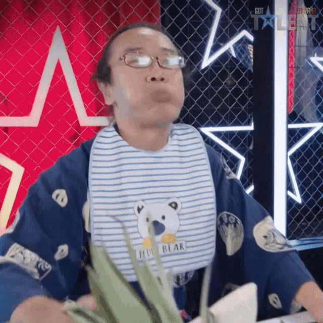 a man wearing glasses and a bib that says it 's bear