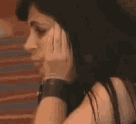 a woman is covering her mouth with her hand while wearing a watch .