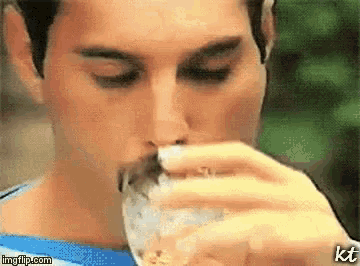 a close up of a man drinking from a glass with the watermark kt