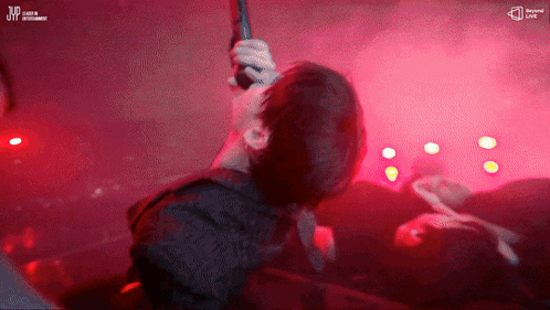 a man holding a microphone in front of a crowd with a jvc logo on the bottom