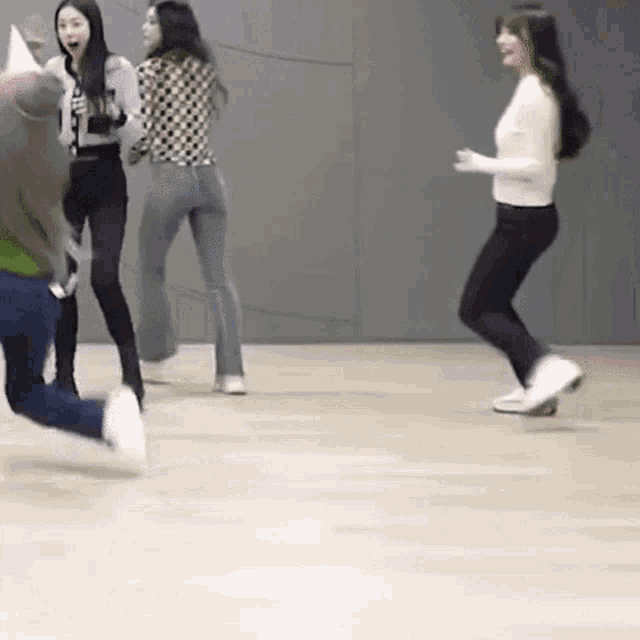 a group of young women are dancing together on a wooden floor .