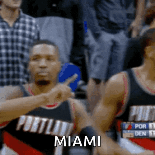 a portland basketball player is pointing at the crowd and the word miami is visible