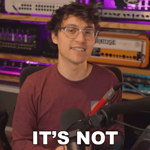 a man sitting in front of a microphone with the words it 's not above him