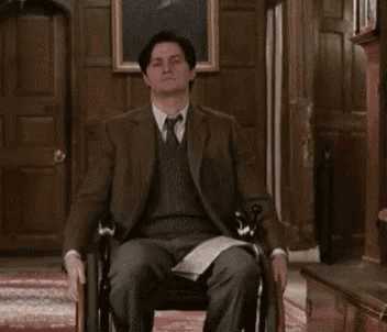 a man in a suit and tie is sitting in a chair with his legs crossed .