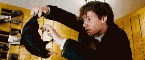 a man in a suit is holding a rat in his hands in a room .
