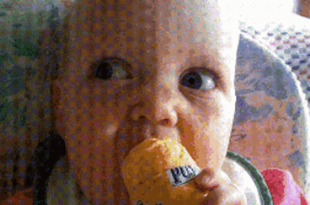 a baby in a high chair is chewing on a piece of food that says pur