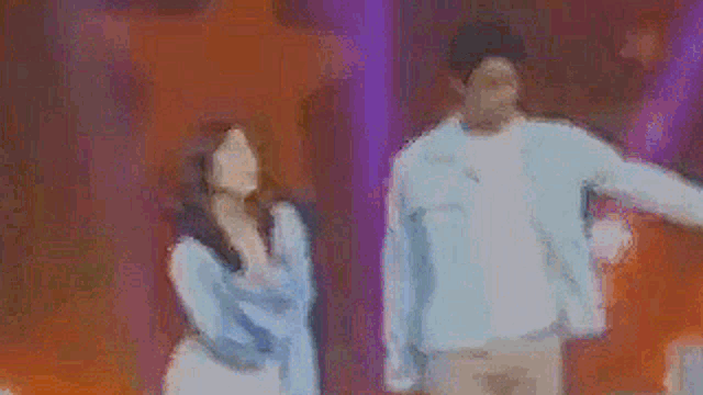 a man and a woman are standing next to each other in a room .