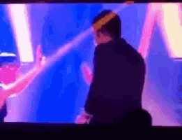 a man in a suit is standing in front of a blue screen