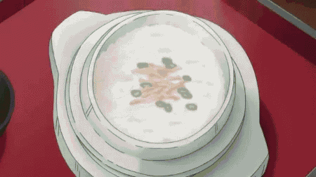 a bowl of soup is on a red table .