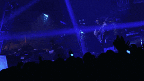 a man playing a guitar in a dark room