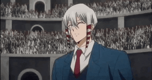 a man in a suit and tie is standing in front of a crowd in an amphitheater .