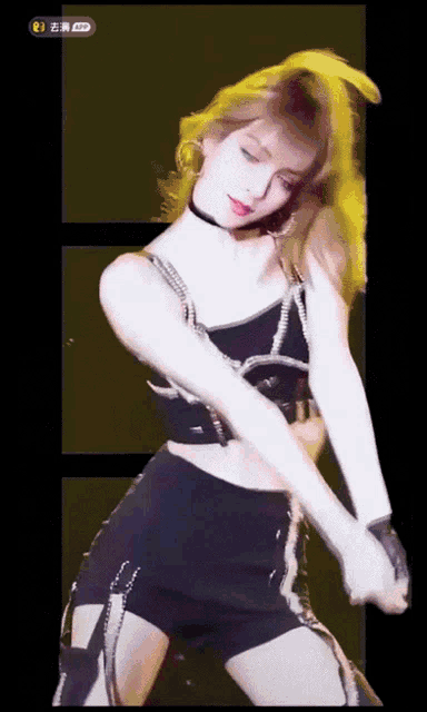 a woman in a black top and shorts is dancing on a stage