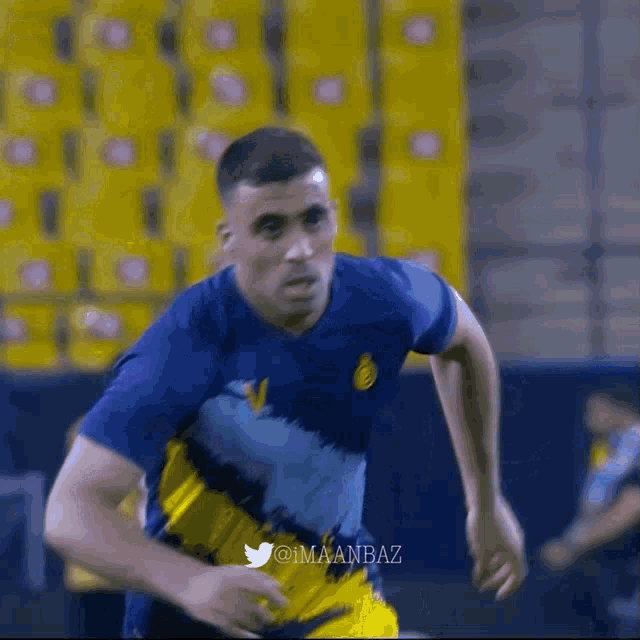 a soccer player wearing a blue and yellow jersey with the twitter username @imaanbaz