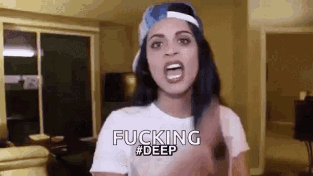 a woman wearing a hat and a white t-shirt is making a funny face and says `` fucking deep '' .