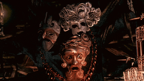 a couple of masks are sitting on a dark surface
