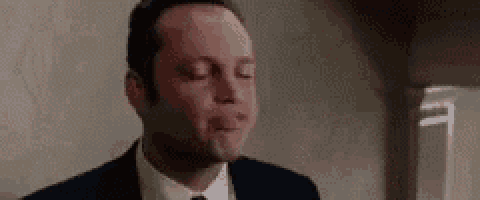a man in a suit and tie is crying with his eyes closed .