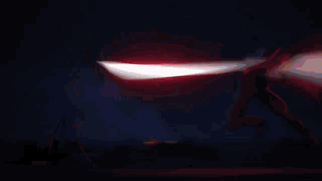 a candle is lit up in the dark with a red and blue light coming out of it