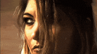 a close up of a woman 's face with her hair covering her eyes