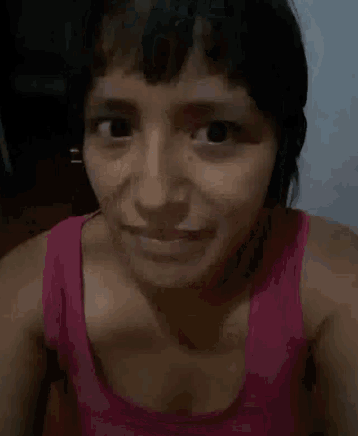 a woman in a pink tank top is smiling