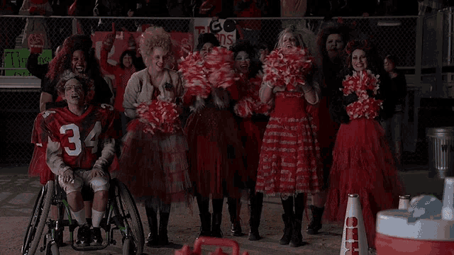 a group of cheerleaders and a football player wearing number 34