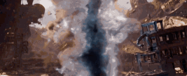 a very large explosion is taking place in the middle of a city with a lot of smoke coming out of it .