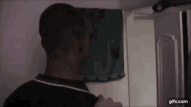 a man is standing in front of a closet with a towel hanging on the door .