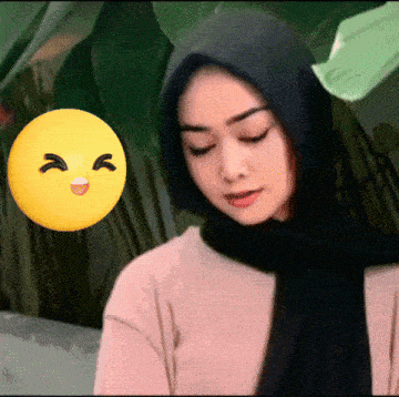 a woman wearing a scarf and a hijab with a yellow smiley face in the background