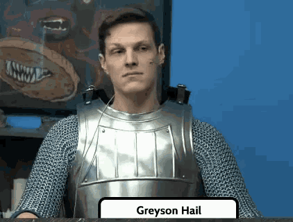 a man in armor is sitting at a table with a sign that says greyson hail on it